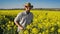 Male Farmer in Oilseed Rapeseed Cultivated Agricultural Field Examining and Controlling The Growth of Plants