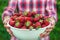 A male farmer picks strawberries in the garden. Selective focus.