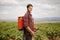 Male farmer spraying a pesticides on a grapevine field