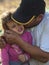 A male father and his young daughter laugh after picking olives on an island in Greece