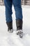 Male feet in black boots, winter walking in snow