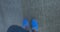 Male feet in blue shoes walking on street