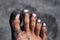 Male feet covered by black sand