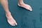 Male feet and footprints on volcanic black sand beach shore