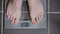 Male feet on glass scales, men`s diet, body weight