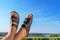 Male feet in leather slippers relaxing on balcony