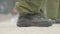 Male feet in military boots marching on outdoor polygon. Unrecognizable soldiers training outdoors. Army recruits