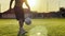 Male feet of professional footballer kicking ball at green field. Legs of young man juggling soccer ball on stadium at