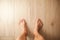 Male feet stand on wooden floor