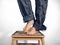 Male feet standing barefoot on chair making pose