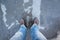 Male feet standing on frozen puddle with thin ice