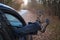 Male feet in trekking boots sticking out the car window