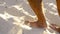 Male feet walking on sand