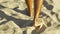 Male feet walking on sand