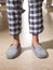Male feet wearing grey bedroom slippers