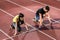 Male and female athlete in starting position at starting block