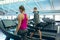 Male and female athletic exercising on treadmill in fitness center