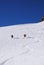 Male and female backcountry skiers draw first tracks in the fresh powder snow in the Alps