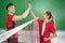 Male and female badminton players doing high five between net