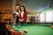 Male and female billiard players with cue
