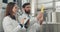 Male and female brewery workers in lab coats checking quality and talking. Man with tablet and woman holding glass tube