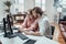 Male and female colleagues looks at telephone sitting at table in office