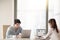 Male and female colleagues working at office table using laptops