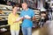 Male and female customers shopping together, searching sneakers in store