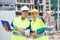 Male and female european builders talking about their work while standing in construction plant.