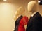 Male and female faceless mannequins in suits and dresses stand in a row in the store