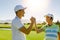 Male and female friends giving high-five at golf course