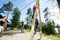 Male And Female Friends Pulling Ropes To Balance Woman On Wooden