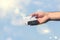 Male and female hands with a small white gift boxe on the blue sky background.