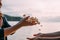 Male and female hands toss a full handful of shells at sunset