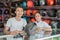 Male and female shop assistants standing near a helmet display rack background