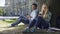 Male, female strangers sitting under tree, looking at each other alternately