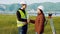 Male and female surveyors in working uniform and helmets smiling Shake hands after the deal ends, that mean good work