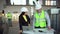 Male and female warehouse workers are looking at a laptop computer and discussing the logistics of their business. 4 k