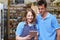 Male And Female Workers In Delicatessen Store Using Digital Tablet