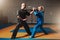 Male and female wushu fighters exercises indoor