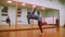 Male fighter performs martial tricks with dance elements in the sport gym in front of the mirror