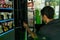 Male filling a coffee vending machine in a self-service grab shop in Milan, Italy