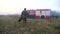 Male firefighter in uniform going on dry grass at countryside. Professional fireman walking after hard work to fire