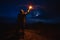 The male with a firework stick standing on the night mountain.