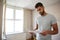 Male First Time Buyer Looking At House Survey In Room To Be Renovated