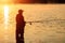 Male fisherman at dawn on the lake catches a fishing rod. Fishing hobby vacation concept. Copy space