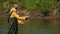 Male fisherman throws a float, fishing on the river, standing in the water