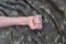 Male fist with brass knuckles on the background of a camouflage jacket. The concept of skinhead culture, handmade melee weapons