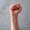 Male fist on gray background. Raised fist as human hand up with protest, victory, strength, power. Counting, aggression, brave