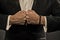 Male fists with swollen veins and bracelet on formal suit background. Confrontation concept. Hand of business person